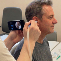 Patient having ear examined with an otoscope camera at Berkeley Ear Wax Removal Clinic